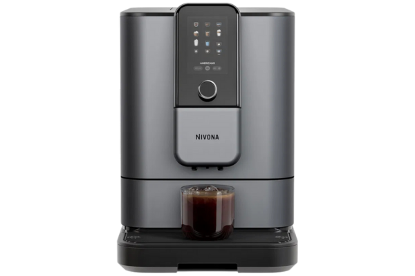 Nivona Kaffeevollautomat in grauer Frontansicht mit frisch gebrühtem Kaffee im Glas.