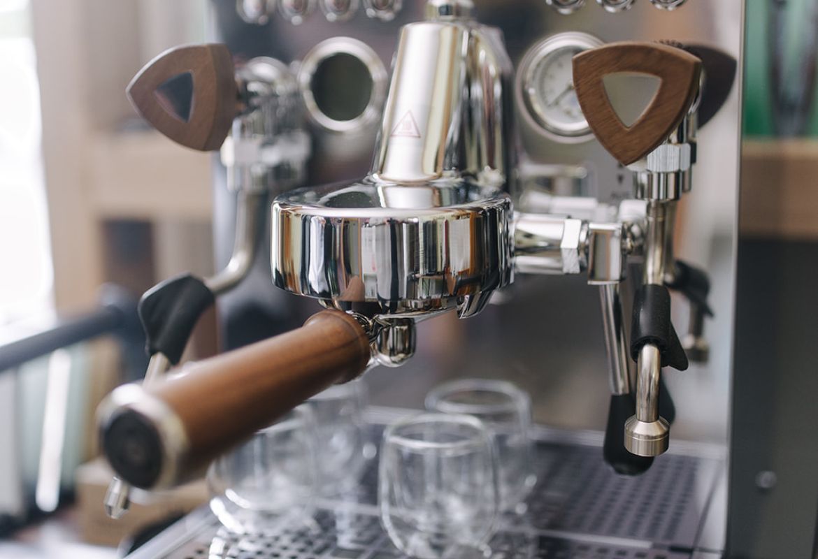 Graef Siebträgermaschine aus Edelstahl mit Holzgriffen und eingesetzten Espressogläsern auf der Abtropffläche.