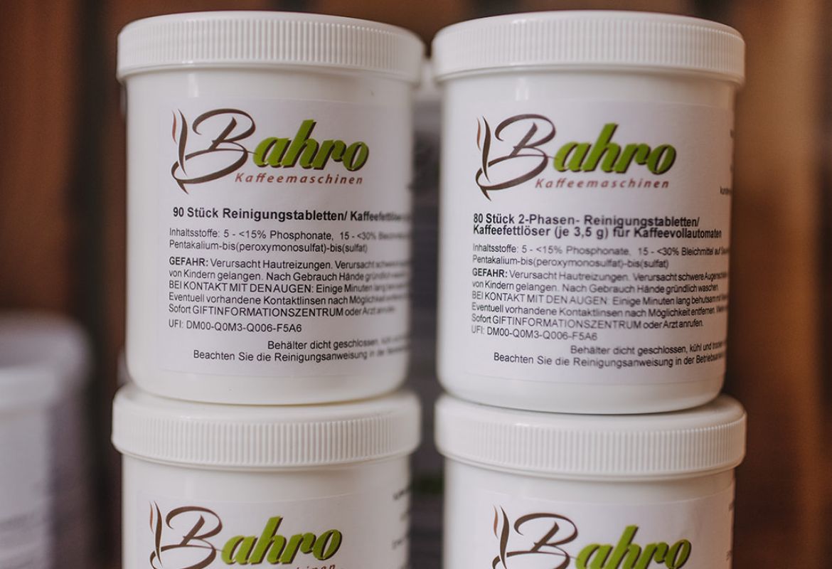 Mehrere Dosen Bahro Reinigungstabletten für Kaffeemaschinen ordentlich im Regal gestapelt.