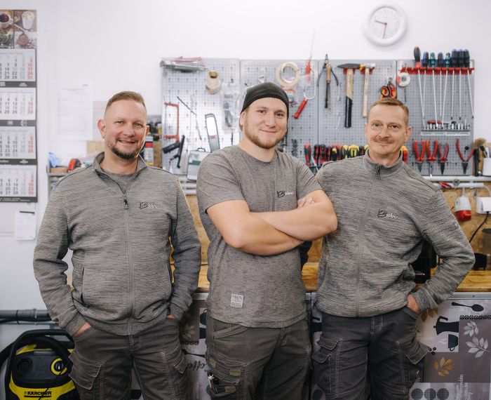 Serviceteam von Bahro Kaffeemaschinen in der Werkstatt vor der Werkzeugwand.